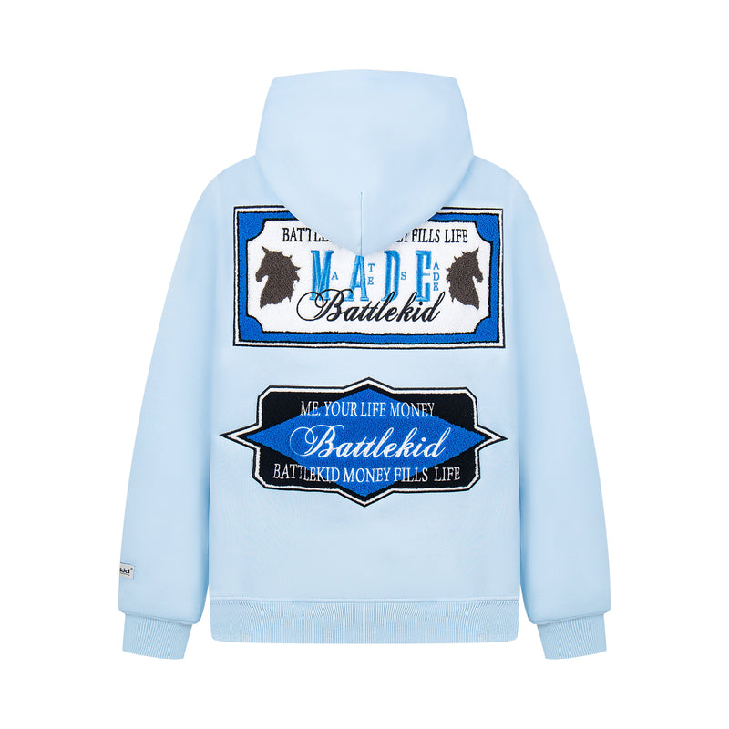 Light blue hoodie back view with large blue and black embroidered MADE badge graphic