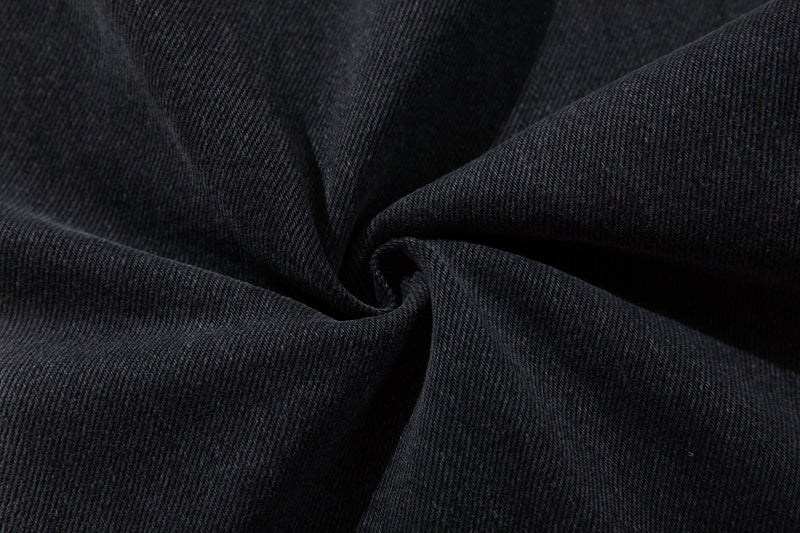 Close-up of folded washed black denim fabric texture
