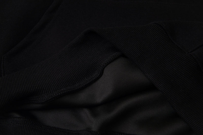 Black hoodie fabric close-up showing soft ribbed knit texture