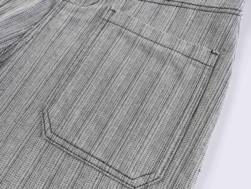 Close-up of back pocket on gray textured pants with stitched pocket opening