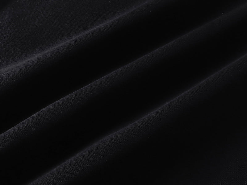 Close-up of black hoodie fabric with subtle diagonal folds and soft knit texture