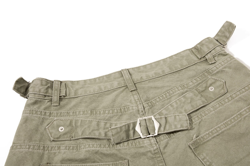 Close-up of olive green denim shorts back waist with buckle strap and belt loop detail