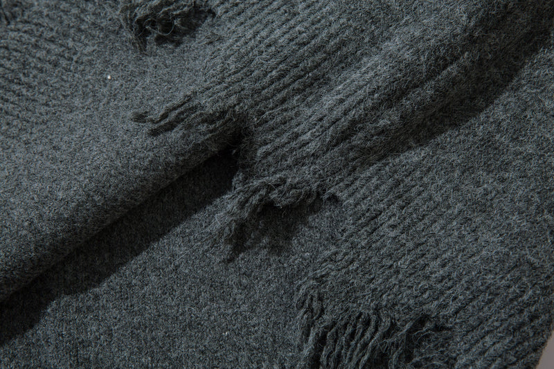Close-up of distressed knit hem and sleeve cuff detail