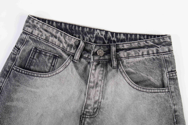 Close-up of the jeans waist showing button closure, belt loops, and front pockets