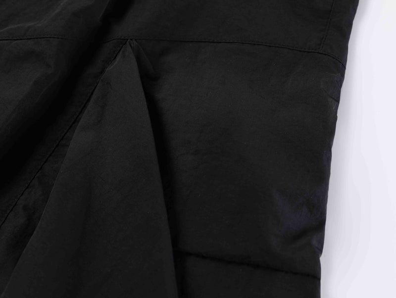Close-up of black shorts front panel and seam detail near the crotch