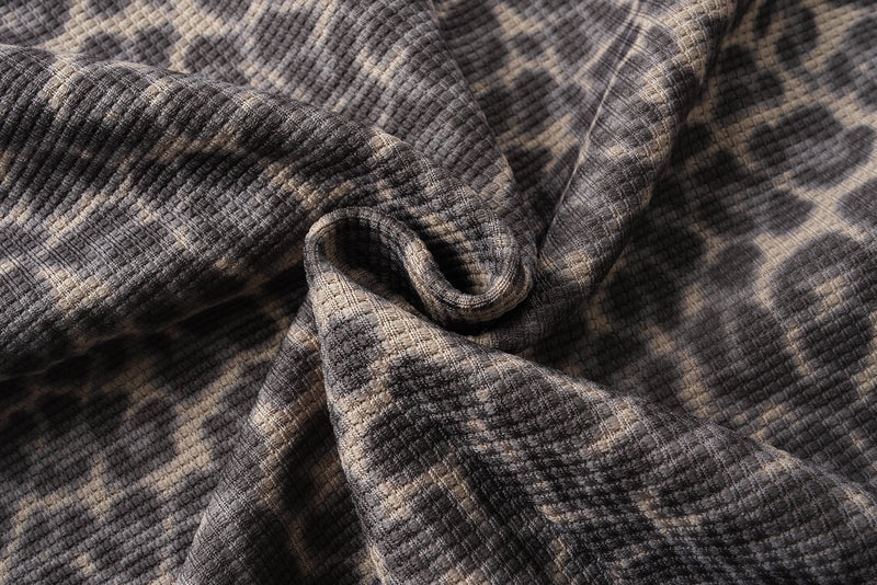 Close-up of leopard print fabric texture gathered in a fold
