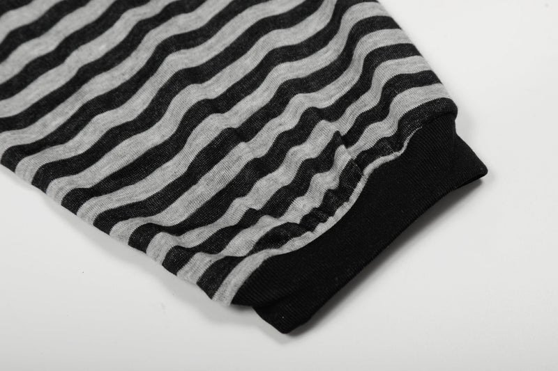 Close-up of gray and black striped sleeve cuff with ribbed black hem