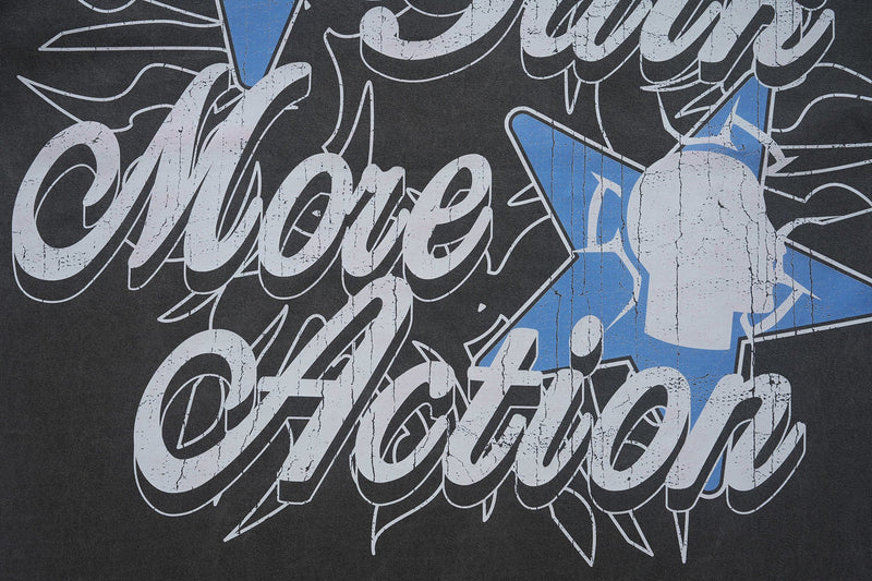 Close-up of a black vintage washed graphic T-shirt with cracked white lettering and blue star accents reading Walk the Talk More Action