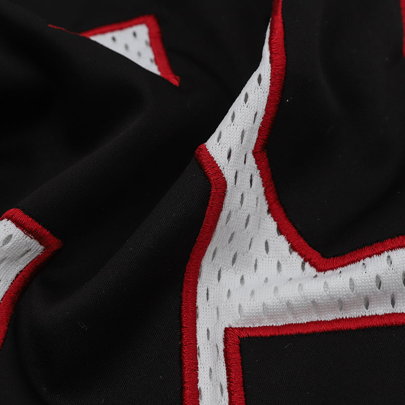Close-up of a black oversized football jersey with bold white number graphics and red embroidered trim