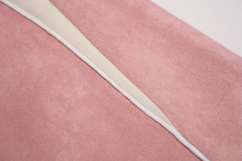 Close-up of pink suede-style T-shirt fabric with a cream contrast panel and white seam piping