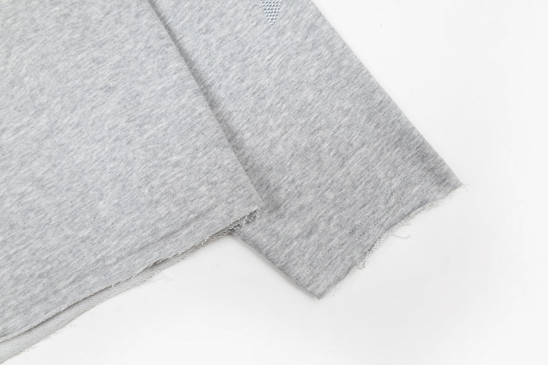 Close-up of heather gray sleeve hem with raw-edge finish