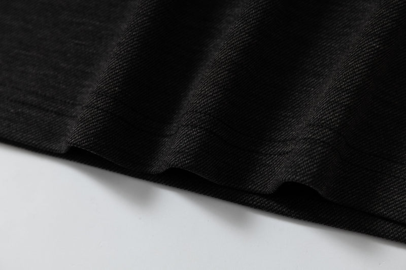 Close-up of black textured fabric on a gothic streetwear raglan t-shirt