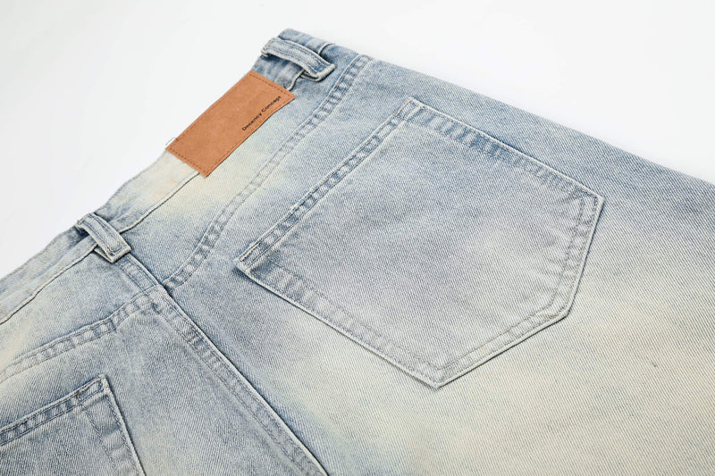 Back waistband and patch pocket on faded light wash denim jeans, close-up