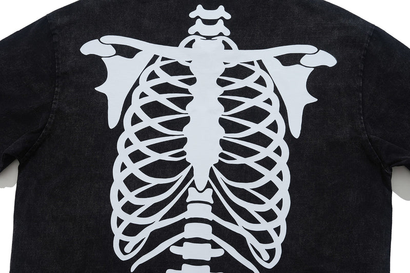 Black washed polo shirt with large white skeleton rib cage graphic on the back