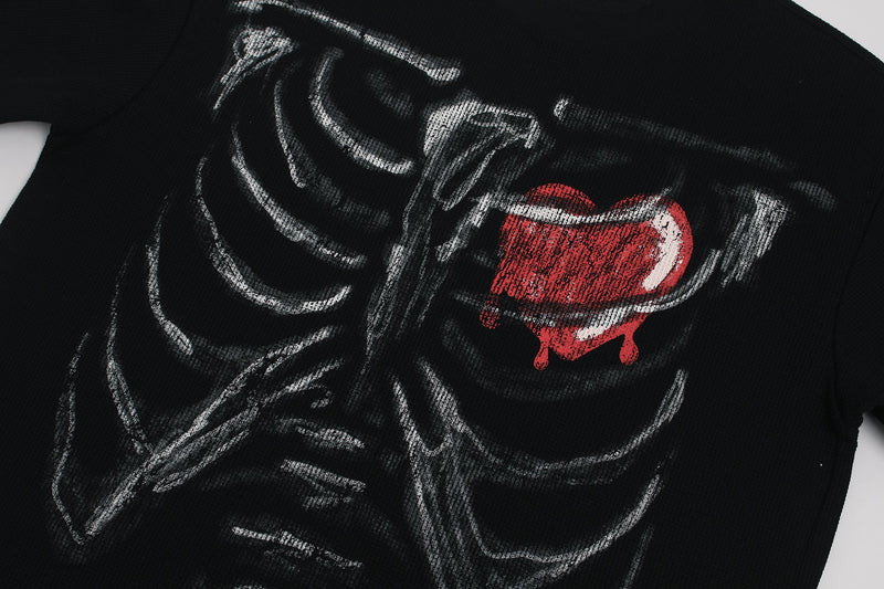 Black graphic tee with a white ribcage print and red melted heart detail on the chest