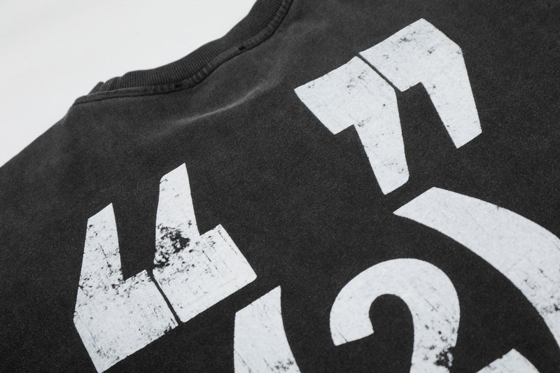 Black vintage washed graphic tee with distressed white lettering and ribbed crew neckline close-up
