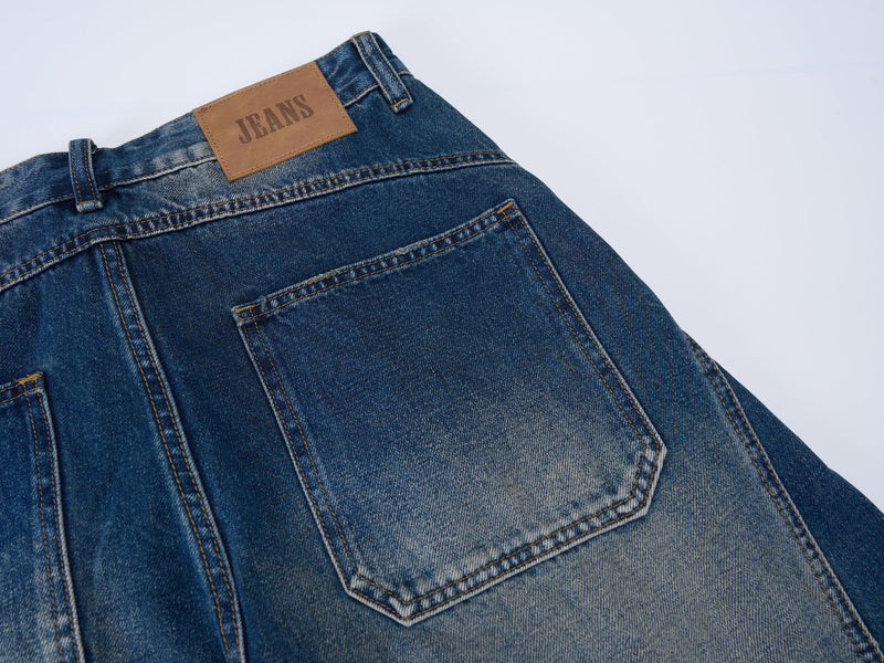 Close-up of the back waistband and pocket on blue jeans with brown JEANS label patch