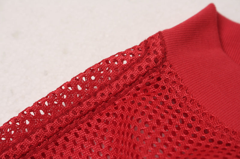 Close-up of a red oversized mesh football jersey collar and shoulder with textured knit details