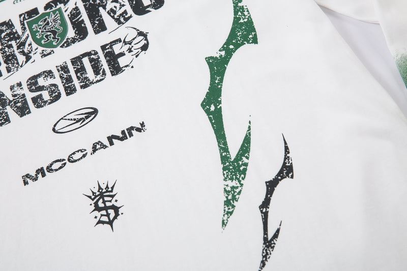 Close-up of white tee front graphic and green side print detail
