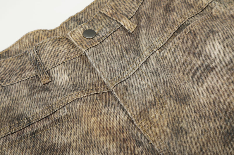 Close-up of denim waistband seam and button on leopard wash jeans