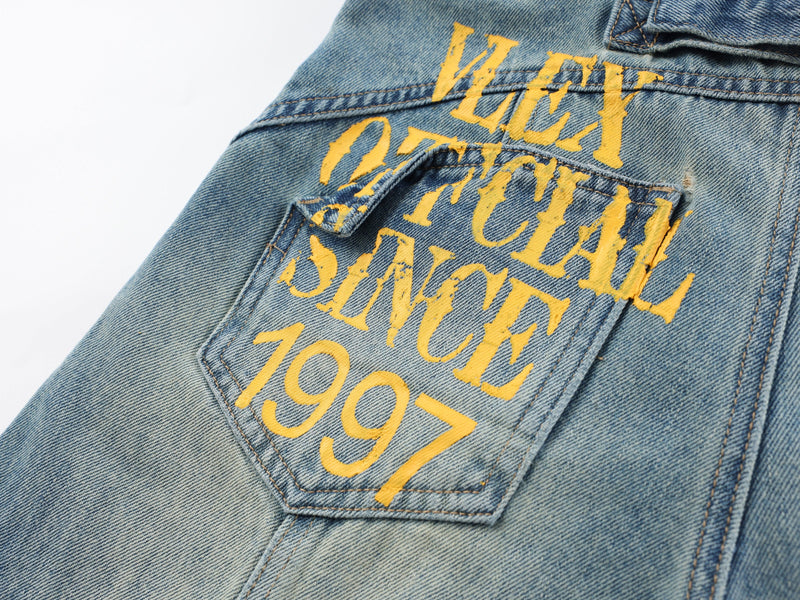 Close-up of the back pocket with yellow graphic text on light blue denim pants