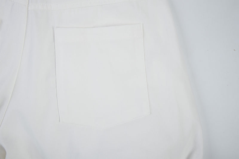 Close-up of white cargo pants side pocket and seam detail