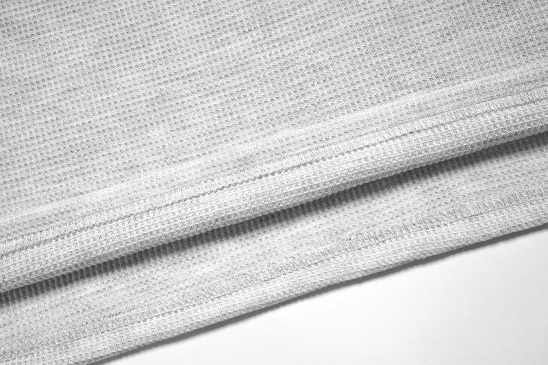 Close-up of white waffle-knit hem with stitched edge