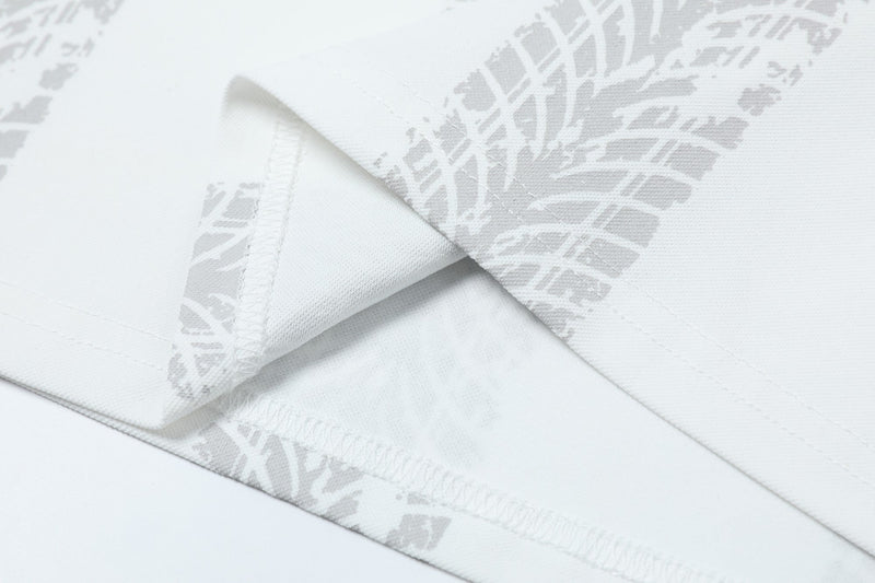 Close-up of white graphic soccer polo shirt fabric with subtle grey abstract print and stitched seams
