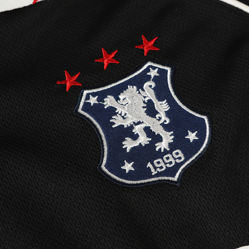 Black football polo jersey with embroidered club crest, three red stars, and 1999 detail on textured fabric