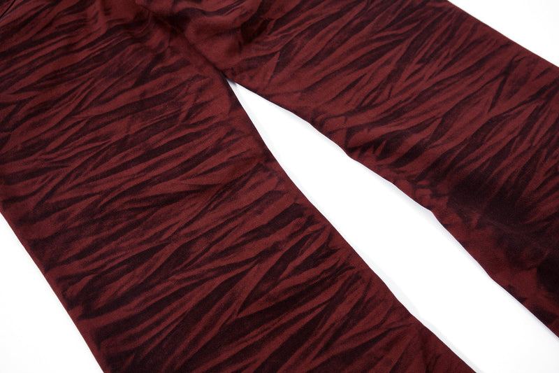 Close-up of the lower legs of burgundy tiger-print flared pants