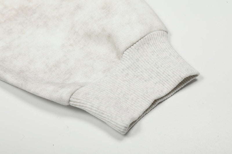 Close-up of ribbed cuff on white hoodie sleeve with vintage-wash fabric