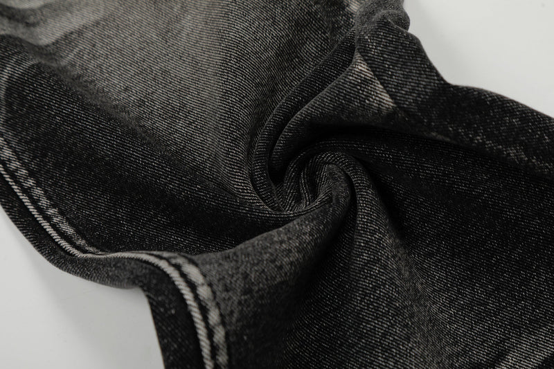 Close-up of twisted black washed denim fabric showing texture and fading