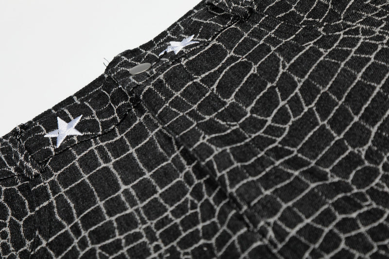 Close-up of black pants waistband with white star embroidery and button