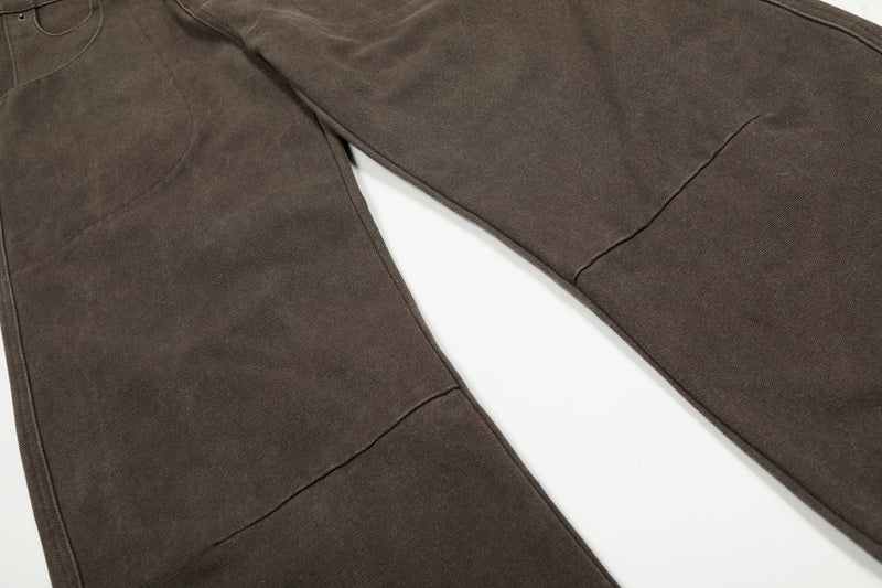 Wide-leg brown pants laid flat, showing both legs and stitched seam lines