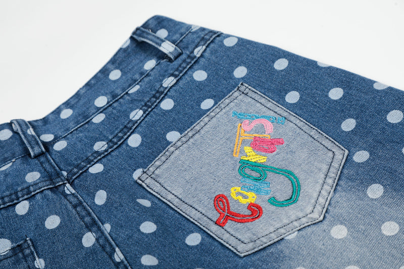 Close-up of back pocket with multicolor embroidered detail on blue denim