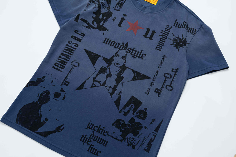 Blue oversized vintage tee with black graphic collage, red star accent, and gothic text on a laid-flat streetwear shirt