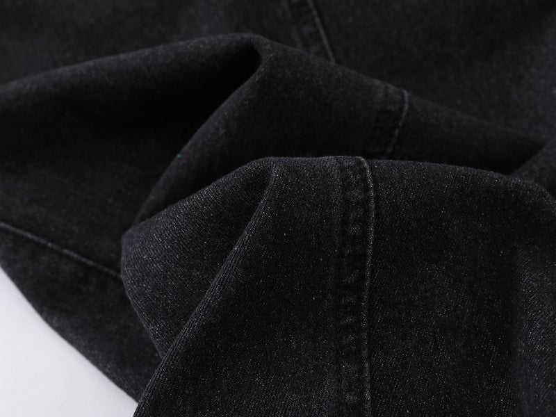 Close-up of black denim fabric texture and folded seam