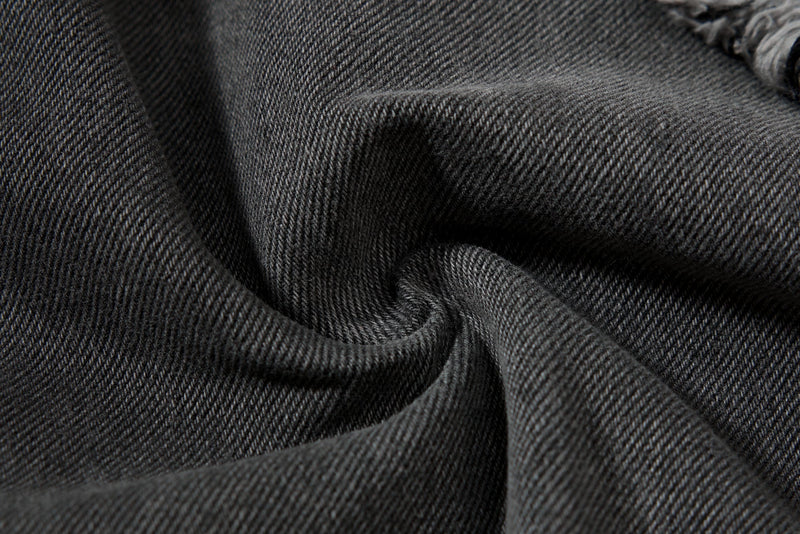 Close-up of black denim fabric texture with folded seam