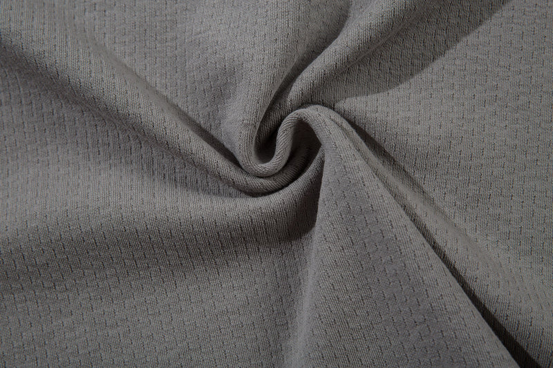 Close-up of gray mesh fabric with soft drape and speckled texture