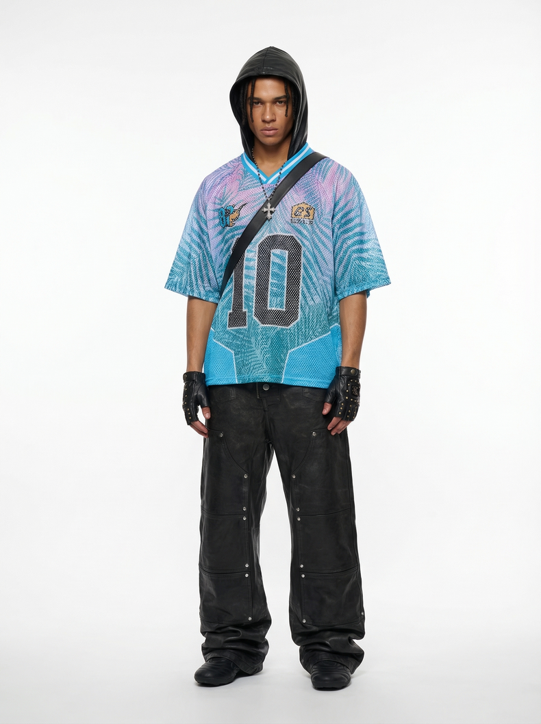 Model wearing a blue-purple mesh jersey T-shirt with hood, number 10 graphic, black cargo pants, and fingerless gloves