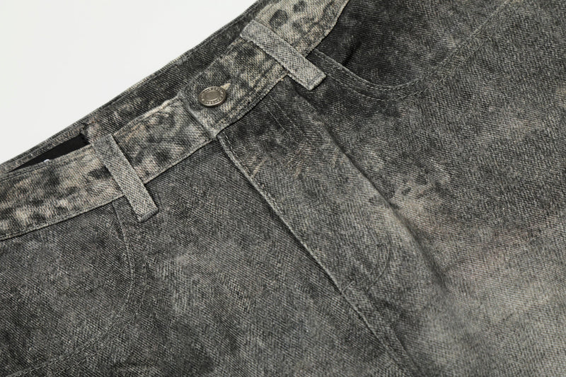 Close-up of front waistband, button, and pocket on washed denim pants