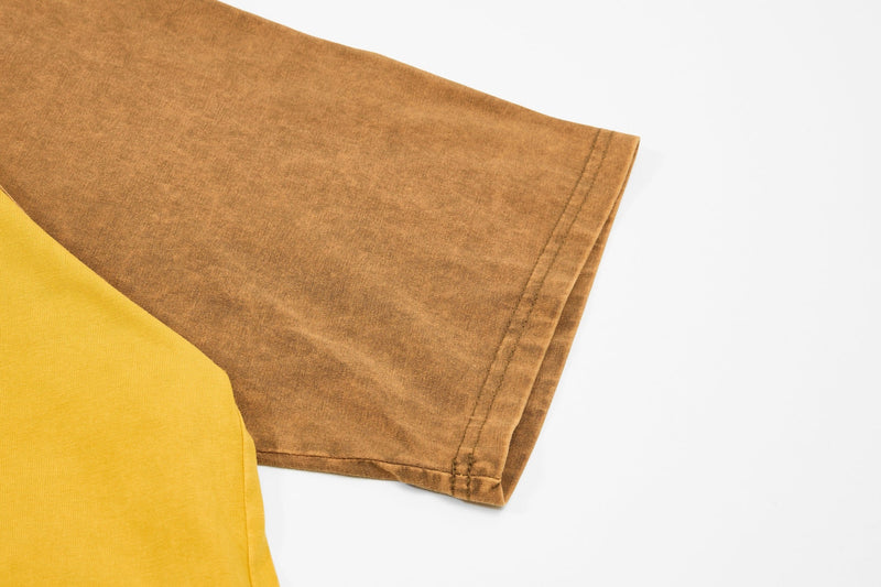 Close-up of a washed raglan tee sleeve in brown and yellow with vintage faded cotton texture on white background
