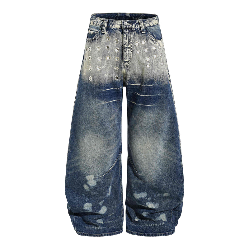 Front view of wide-leg washed denim jeans with silver grommets and heavy distressing