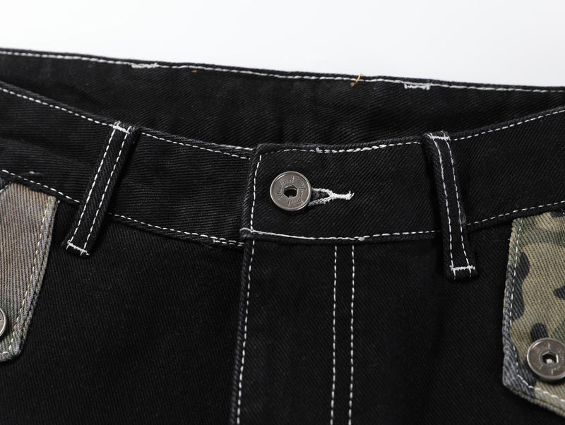 Close-up of the waistband button, belt loops, and white contrast stitching on black denim