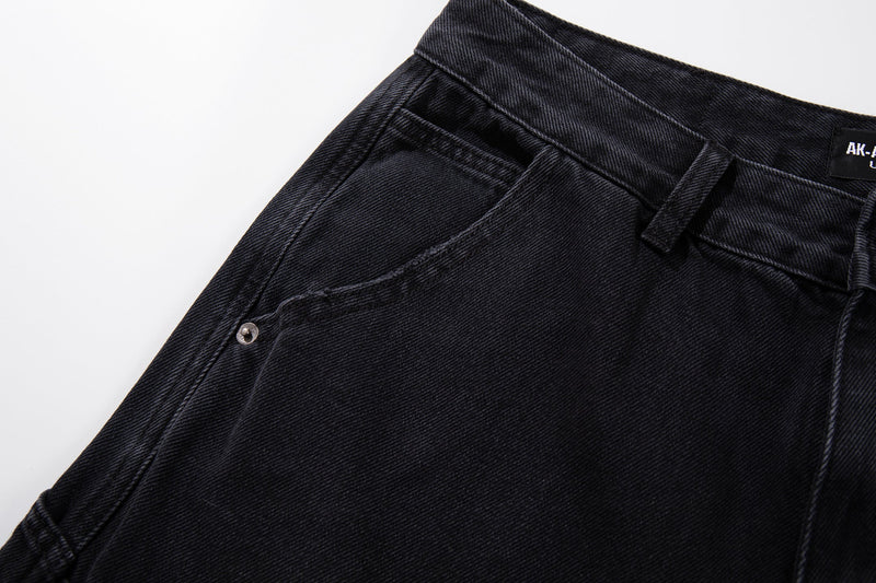 Side waistband view of black carpenter jeans with belt loop and snap pocket tab