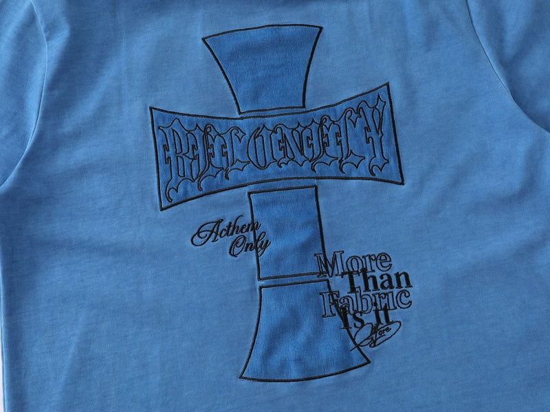 Blue streetwear T-shirt with black cross graphic and gothic Anthem Only More Than Fabric lettering on the front