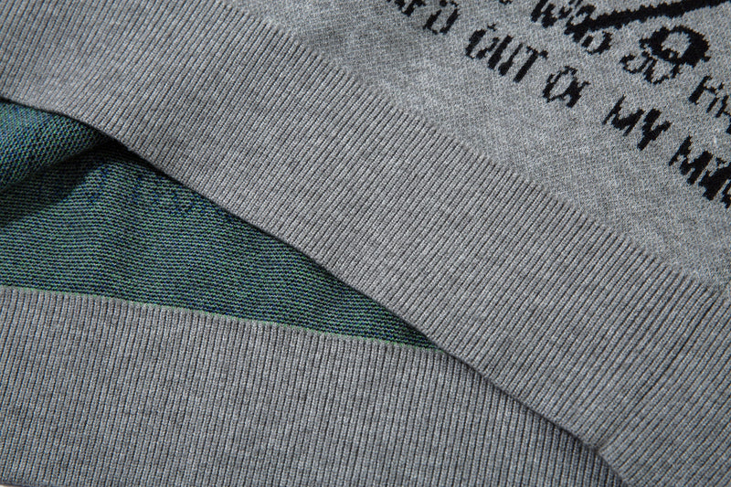 Close-up of gray sweater hem folded over the front graphic with visible knit lining