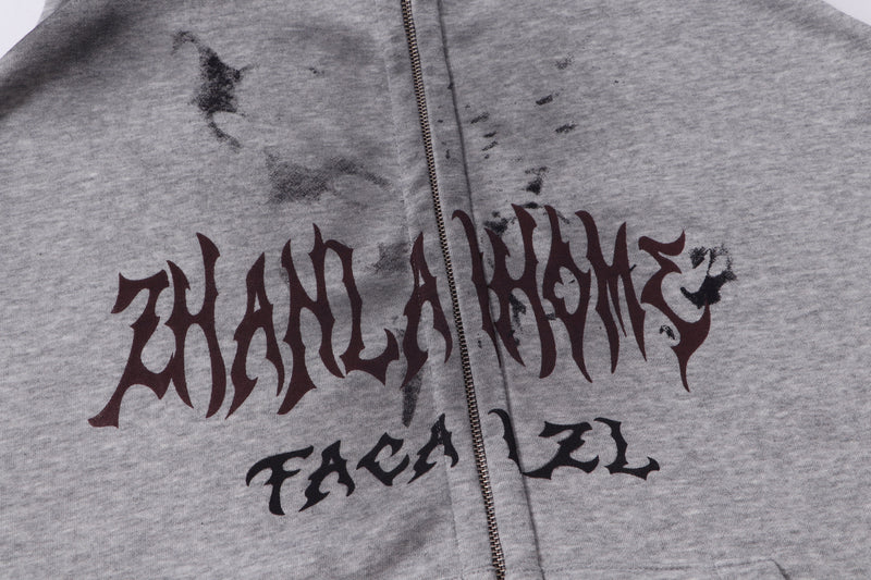 Close-up of gray hoodie front graphic and zipper on the chest