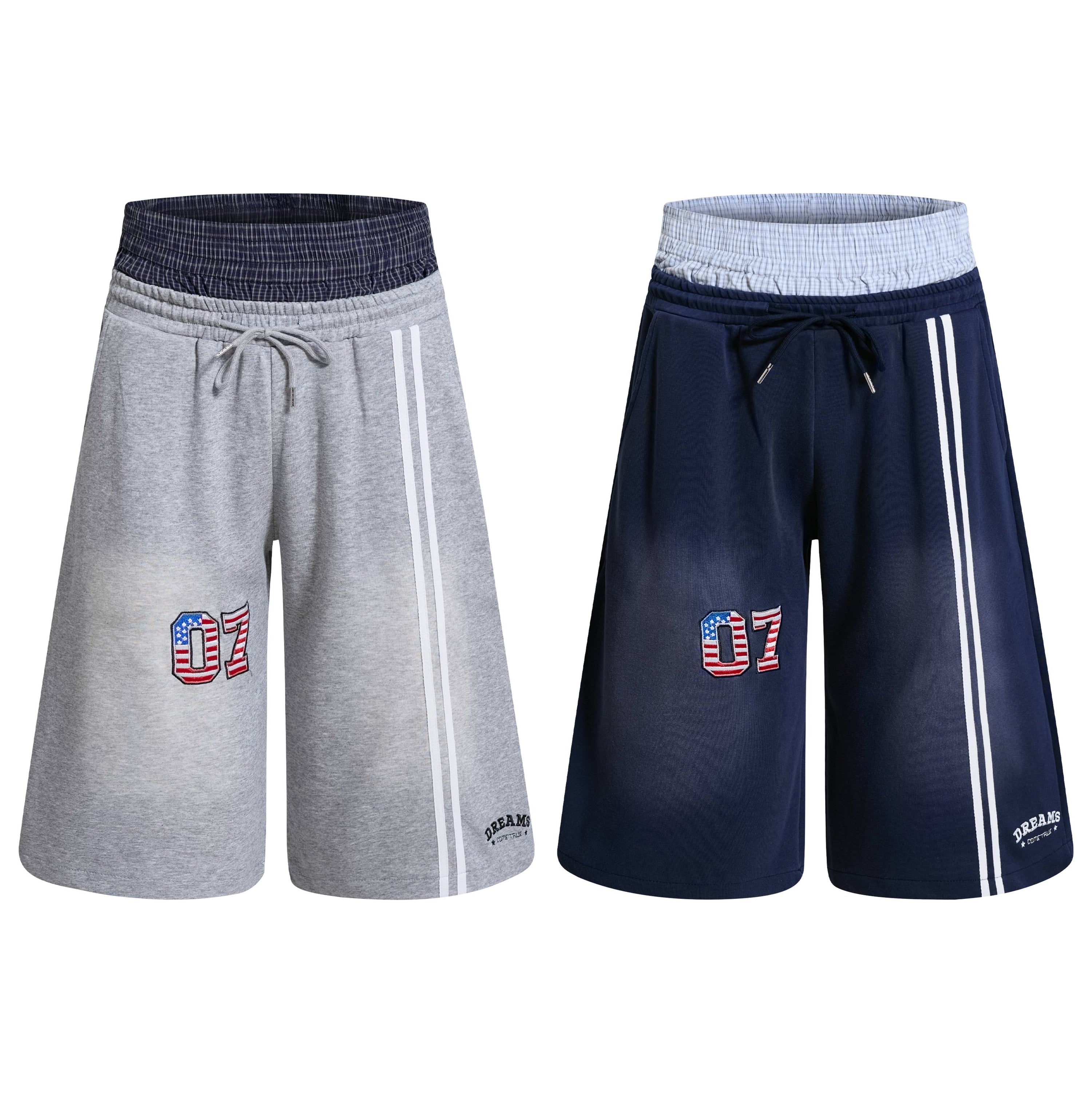 Heather grey double-waist athletic shorts with embroidered 07 varsity patch, white side stripes, and plaid waistband
