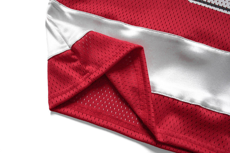 Red and white mesh hockey jersey fabric with a diagonal stripe detail and visible perforated athletic texture